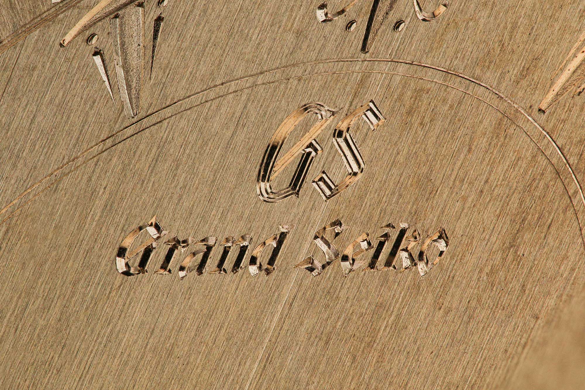 Macro detail of the hand engraving work on a sample dial.