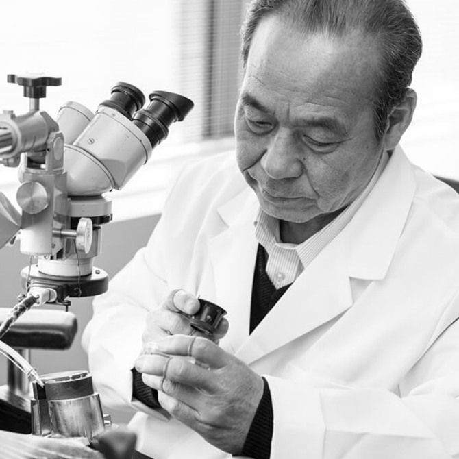 Kiyoshi Terui looking at a dial through a loupe.